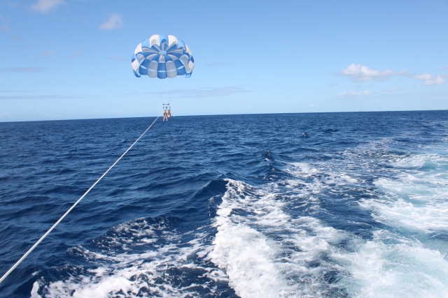 沖縄の青い海でパラセーリングを楽しむ様子
